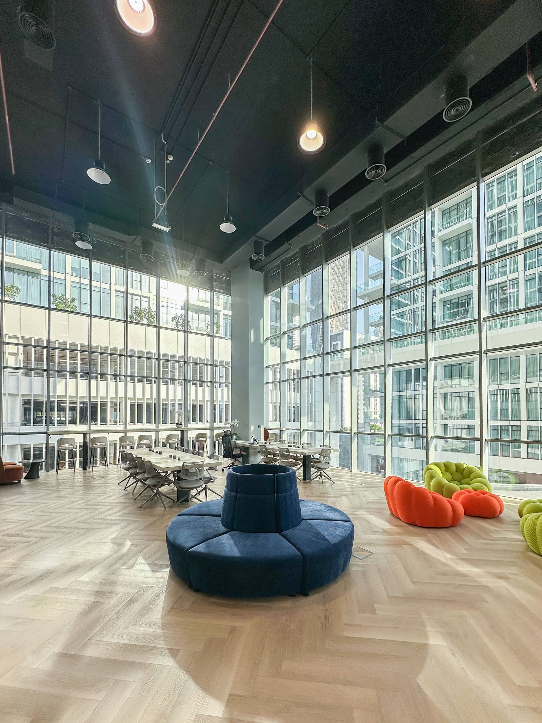 Open coworking space with communal tables and natural lighting at Oh My Desk in Business Bay, Dubai.